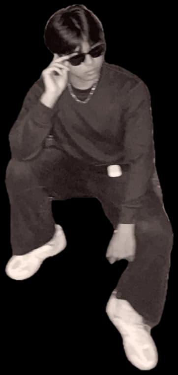 Victor sitting on a flight of stairs, adjusting his sunglasses